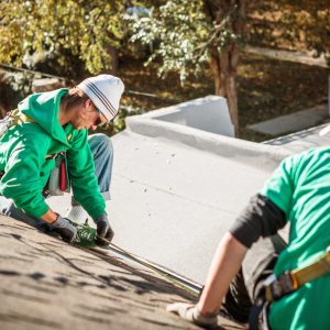 Solar panel installation crew members on roof of house
